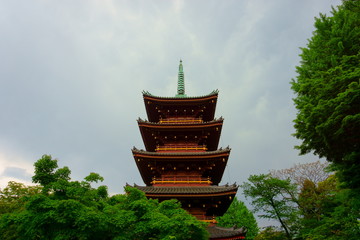 Five Storied Pagoda of Kaneiji Temple at Ueno Park in Tokyo. Gray sky before the rain, green trees