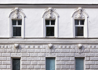 Beautiful facade of a white building with stucco antique architectural decorations front view close...