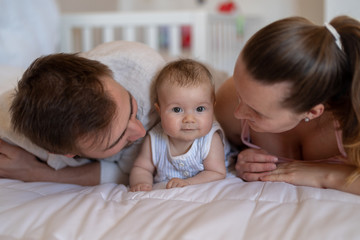 Happy mother and father bonding with their baby girl at home