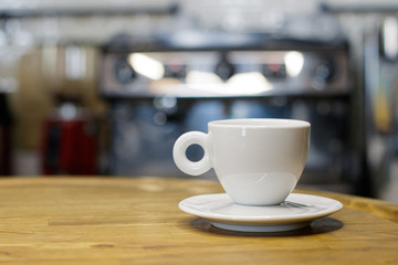Coffee cup on wooden table in coffee shop with blur background bokeh