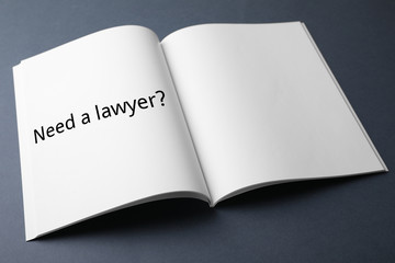 Notebook with text NEED A LAWYER? on dark background