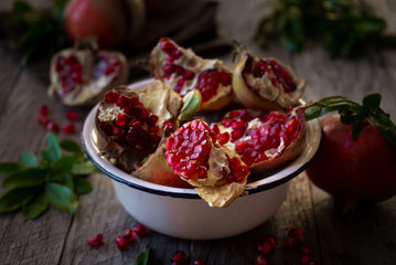 Fresh organic pomegranate fruit with leaves on dark background