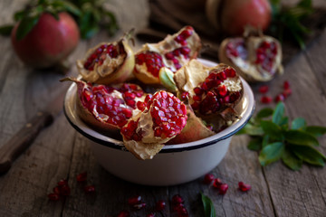 Fresh organic pomegranate fruit with leaves on dark background