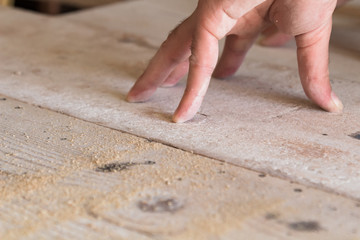 Male carpenter working on old wood in a retro vintage workshop.