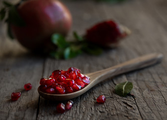 Fresh organic pomegranate fruit with leaves on dark background