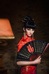 girl in a red Japanese silk dress qipao in a dark room