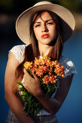 girl in a long dress with flowers on the background of a career lake