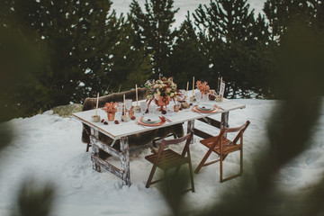 Close up of romantic wedding table in the middle of the mountain. Winter wedding decor.