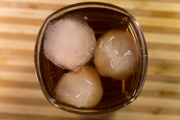 Glass of whiskey on wooden background close up