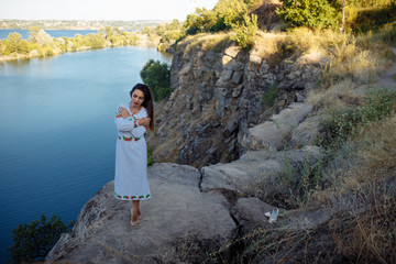 girl in a long dress with flowers on the background of a career lake