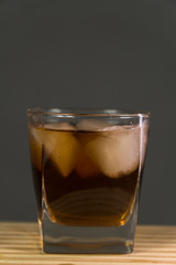 Glass of whiskey on wooden background close up