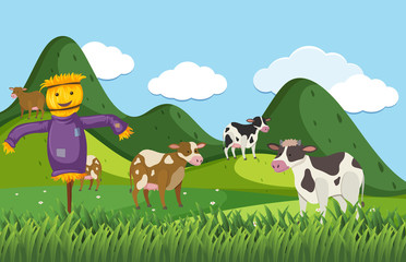 Farm scene with scarecrow and many cows in the field