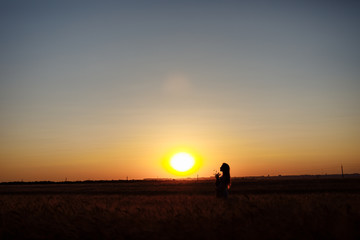 girl at sunset in a wheat field sky