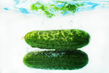 Cucumbers in water on a blue background