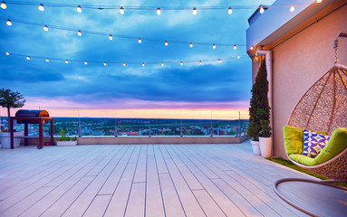 rooftop deck patio area with hanging chair on a sunset - obrazy, fototapety, plakaty