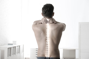 Man suffering from pain in spine in orthopedist's office. Black and white effect