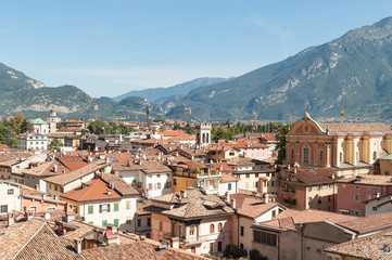 Fototapeta na wymiar Aerial view on old italian town with tile roofed houses and ancient tower on mountain range background