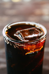 Closeup to Pop or cola water with ice in glass.