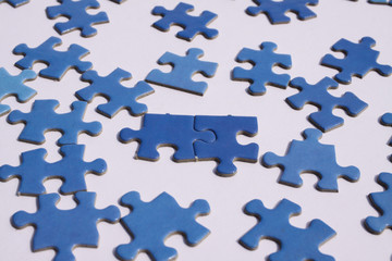 Close up of isolated blue puzzle pieces, white background