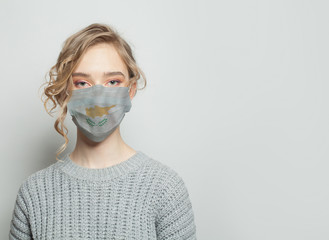 Young woman wearing a face mask with flag. Flu epidemic and virus protection concept