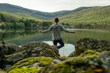 a man alone at a lake doing yoga