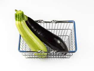 Eggplant and zucchini in the shopping basket. Shopping concept with fresh vegetables on white...
