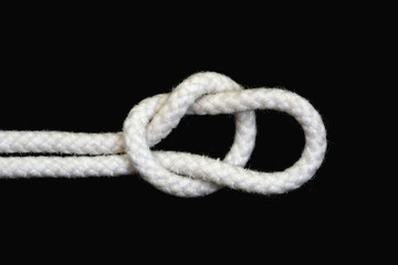 A white rope tied with running knot on black background.