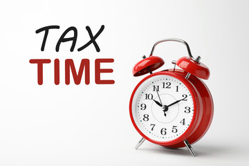 Time to pay taxes. Alarm clock on white background
