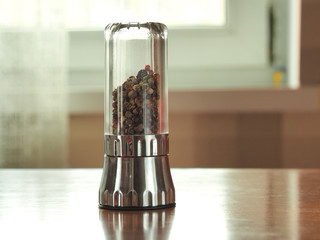 pepper mill on the table and colored pepper in it