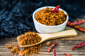 Spicy dried fishes chili paste with wooden spoon and background