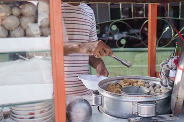 bakso meatball seller preparing the dish for customer