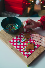 Girl decorates gingerbread cookies with colorful balls