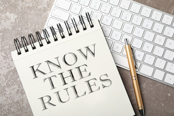 Notebook with phrase Know the rules, pen and keyboard on table, flat lay