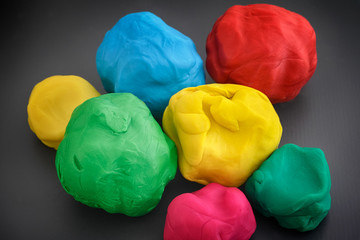 Colorful play clay balls on a dark gray background
