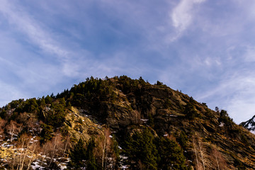A picturesque landscape view of the Pyrenees mountain rocky top and the dramatic blue sky in the Vall de Sorteny (Andorra) natural park on an early cold winter evening
