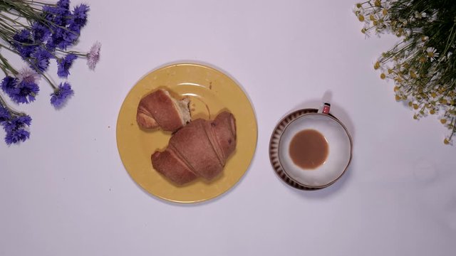 Stop motion animated timelapse of coffee beans daisies flowers and croissants eating in the morning breakfast