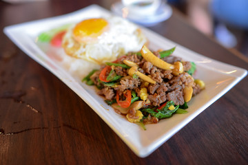 Stir fried Pork with chili and holy basil eat with steamed rice and over hard fried egg - Thai favorite  food