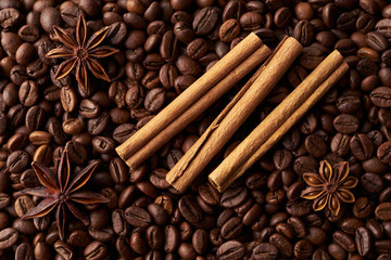 Cinnamon sticks and anise on a heap of roasted whole coffee beans