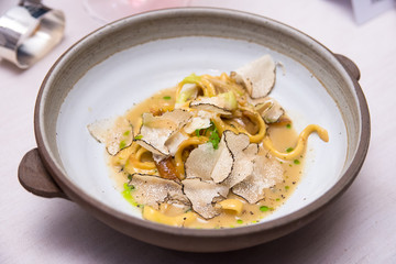Italian cuisine- Yellow spaghetti with black truffle on white plate