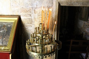 Lighting candles inside a Greek orthodox church.