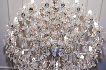 crystal chandelier shines hanging from the ceiling in the room