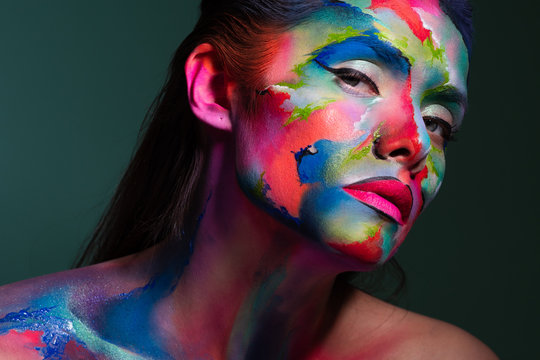 Face art and body art. Creative makeup with colorful patterns on the face. Modern makeup art, bold style,