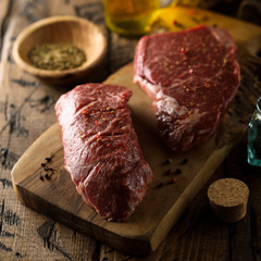 Raw beef steaks on a wooden desk