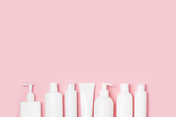 White plastic cans on a pink background. Cosmetics for skin care. Means for washing, disinfecting and washing