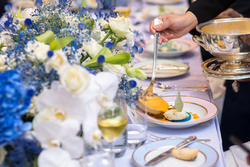 waiter pouring yellow sauce on creative food