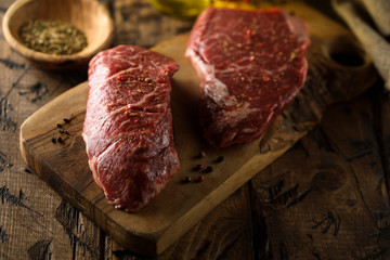 Raw beef steaks on a wooden desk