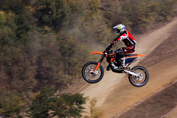 Fototapeta na wymiar The motorcyclist in flight. Motocross. Sports. In the background draw.