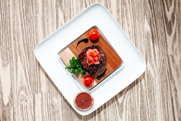 A white plate topped with steak filet mignon and vegetables