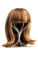 Subject shot of a natural looking blonde wig with bangs and twisted strands fixed on the white metal wig holder. The stand with the wig is isolated on a white background.  