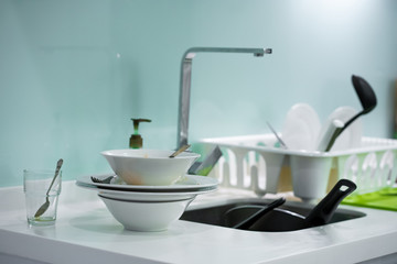 A mountain of dirty dishes in the kitchen sink. Mess in the house